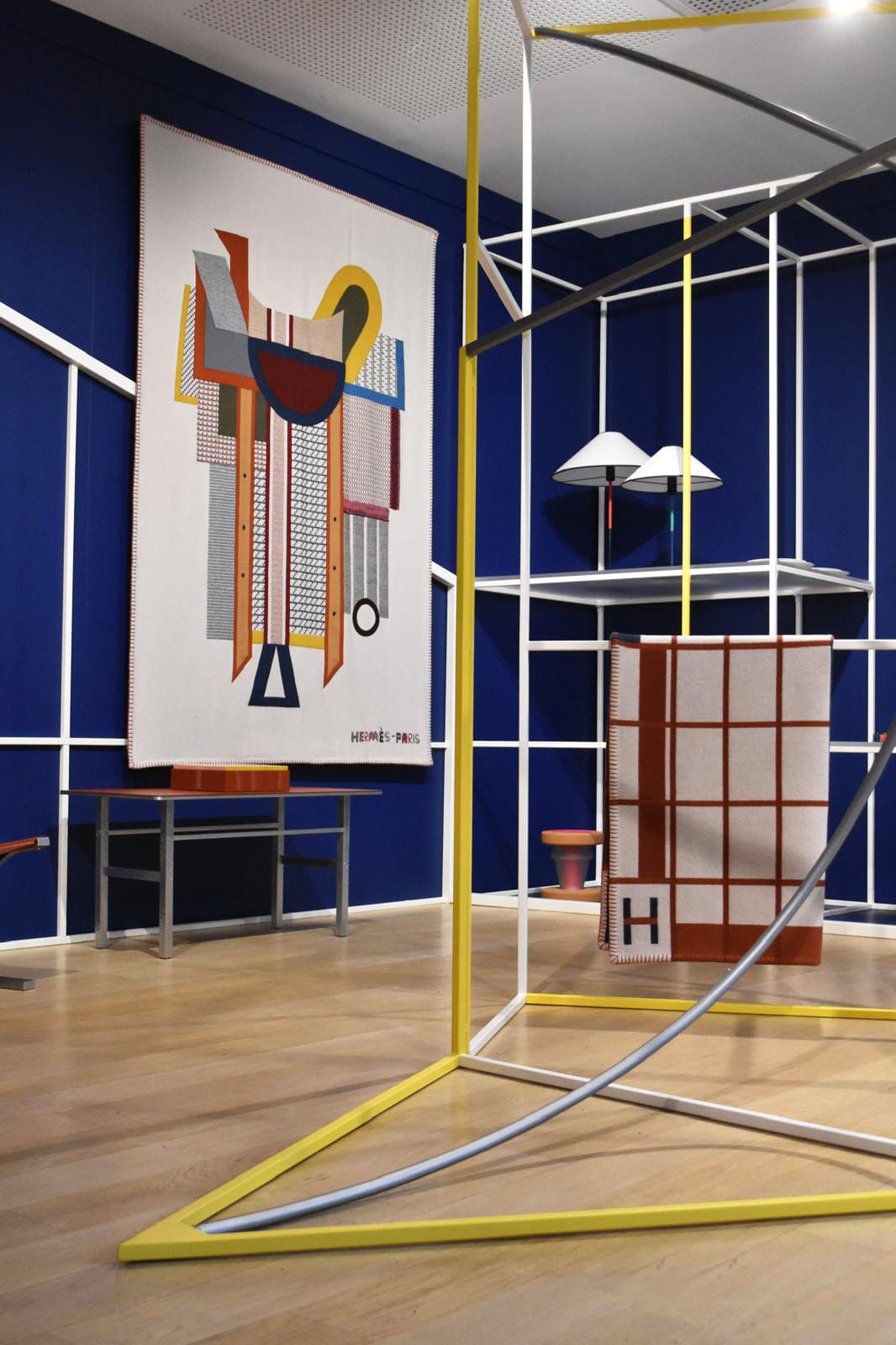 Scénographie présentation Hermès Paris murs bois peints étagères métal thermolaqué