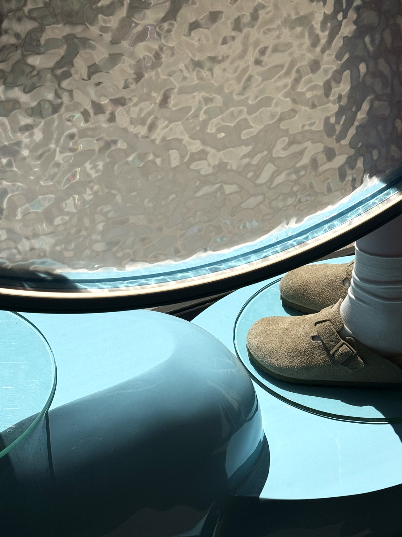 Détail podium bleu et mobilier lumineux effet aqua collection été 2026
