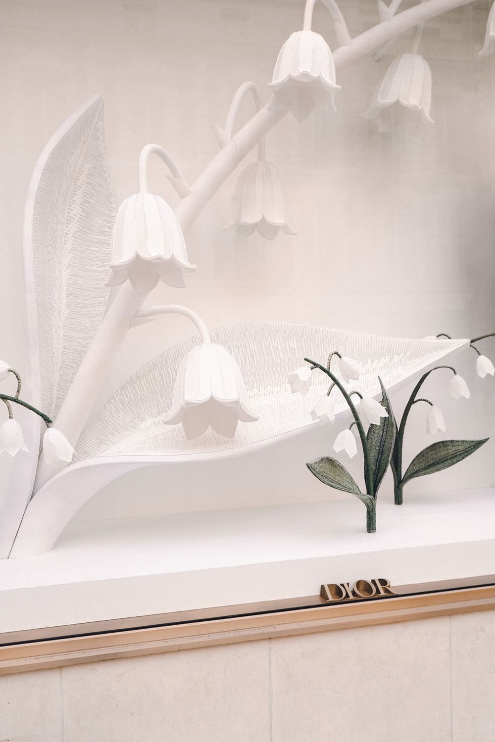Vitrine Dior grand muguet tapissé clochettes éclairées plancher technique scénographie Paris