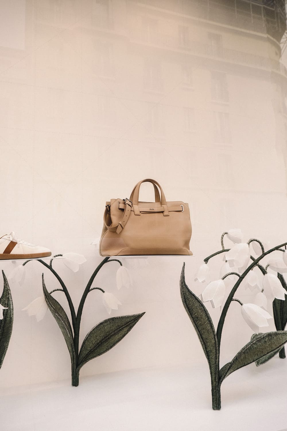 Sac Dior mise en valeur vitrine plancher tapissé muguets scénographie SS25 Paris