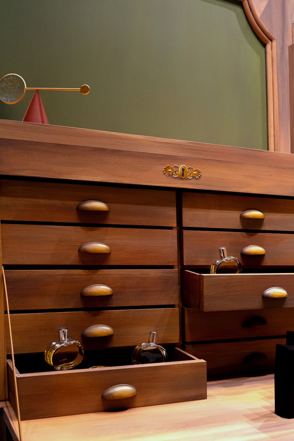 Détail tiroirs buffet scénographie Hermès peinture effet bois métal doré fausse dorure