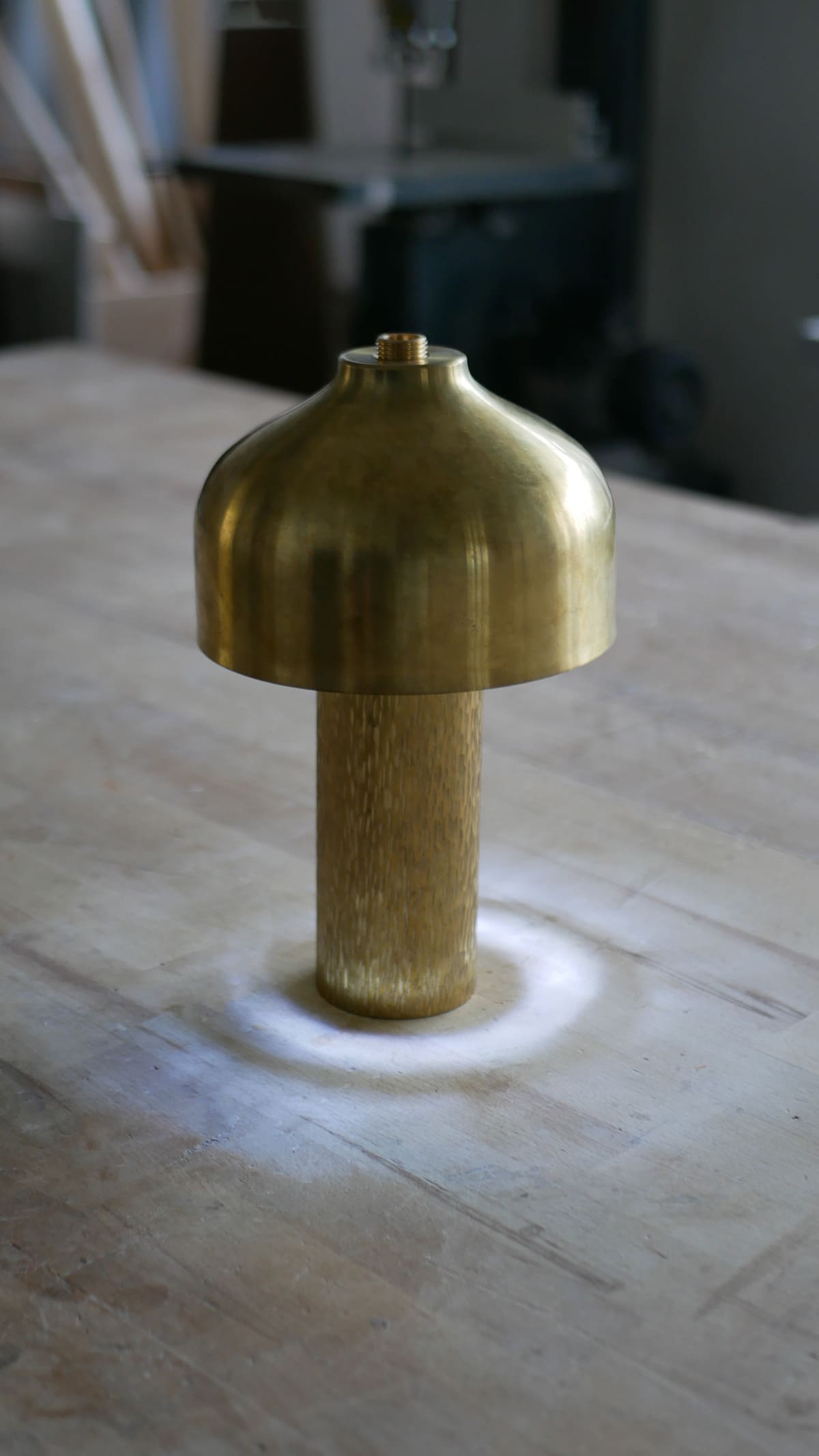 Lampe laiton design allumée atelier objet artisanal dinanderie